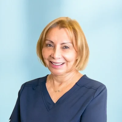 Chiropractic Dallas TX Virginia Meet The Tam Virginia smiling, she has short blonde hair.